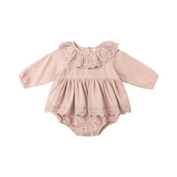Pink baby romper with lace details on a white background