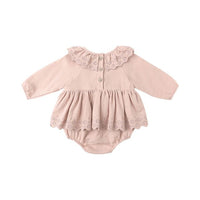 Pink baby romper with lace details on a white background