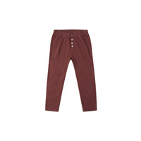 Maroon pants with button details on a white background