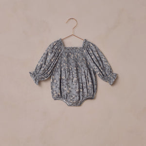 Baby romper with floral pattern on a beige background