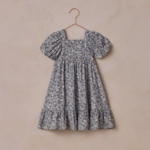 Floral dress on a hanger against a beige background