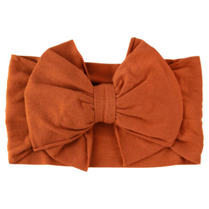 Orange headband with a large bow on a white background