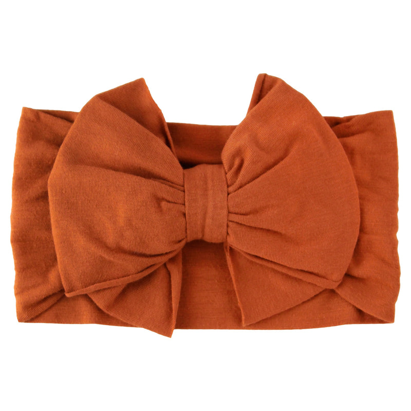 Orange headband with a large bow on a white background