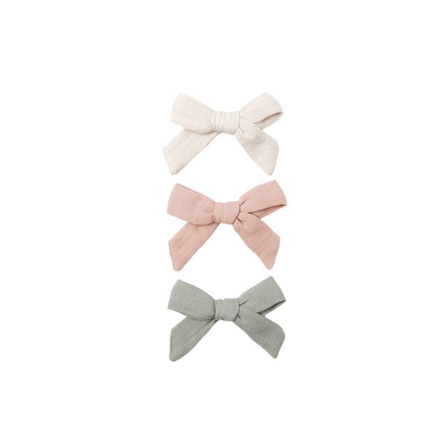 Three fabric bows in beige, pink, and fern green on a white background